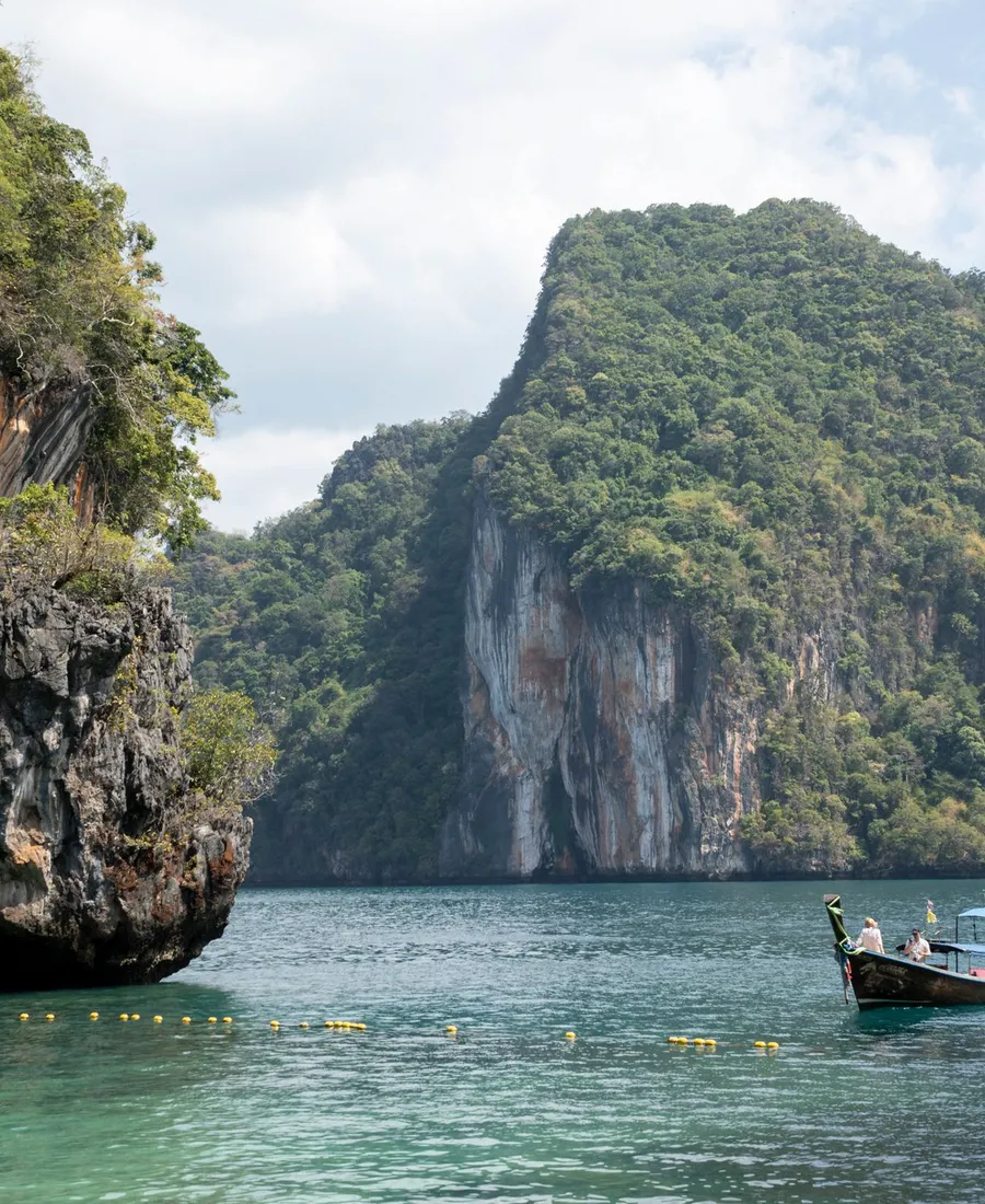 เขาหินปูนกลางทะเลและเรือหางยาวลำเดียว