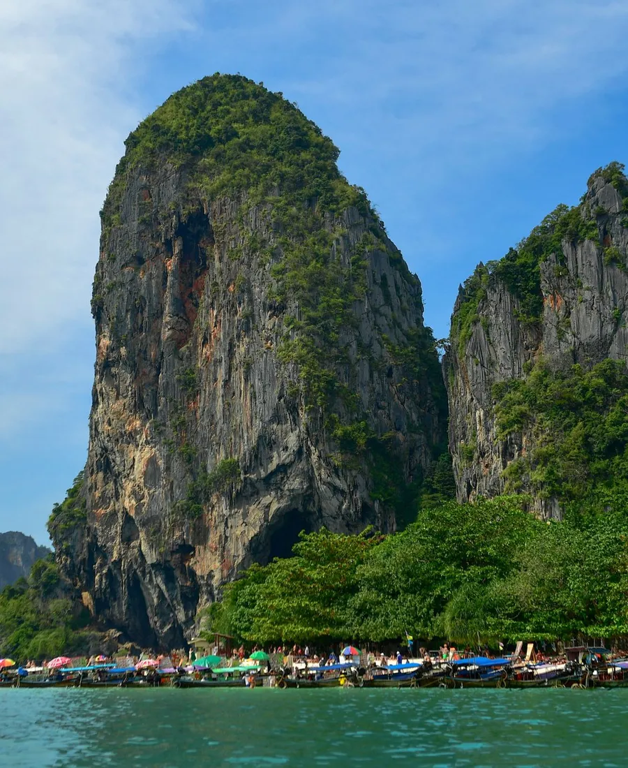 แนวเขาหินปูนริมทะเลและเรือจอดอยู่ไกล ๆ