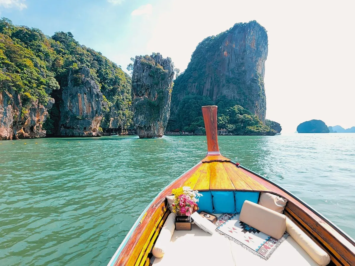 หัวเรือหางยาวแล่นเข้าหาเขาหินปูนกลางทะเล